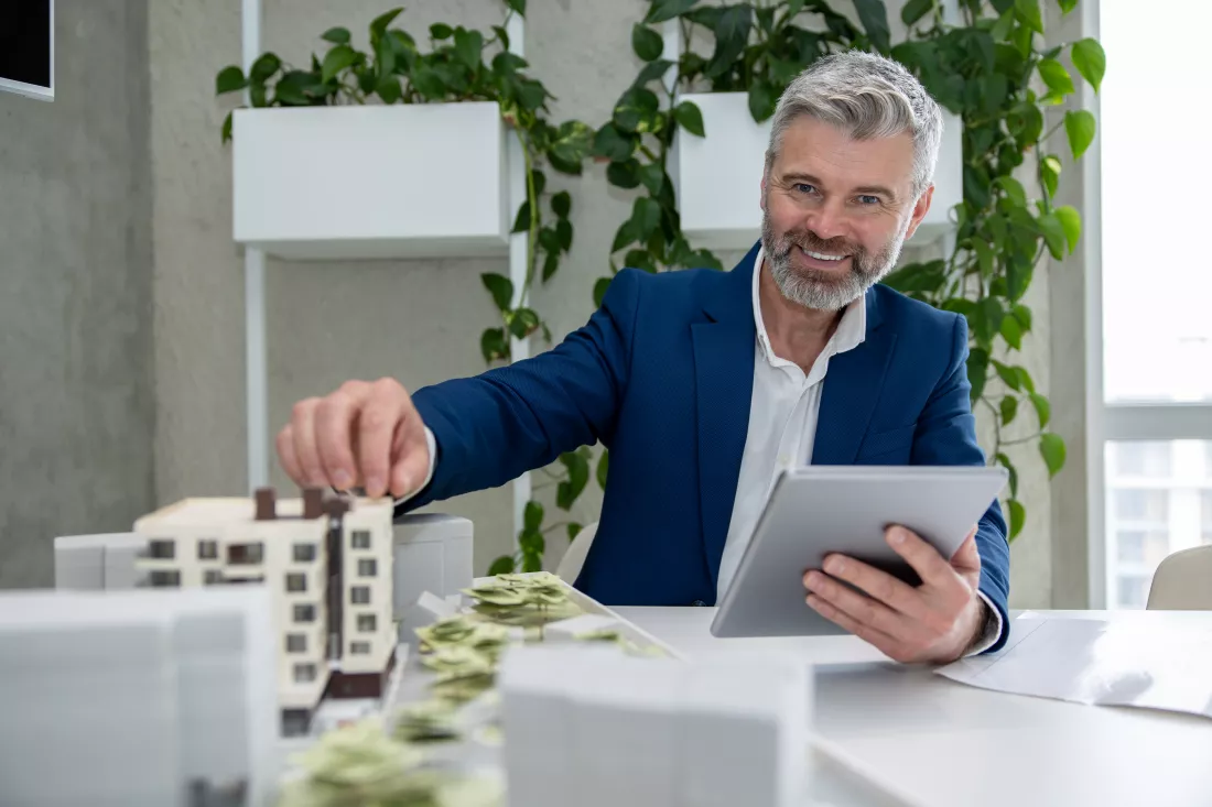 architects-engineer-working-with-blueprint-house-model-office