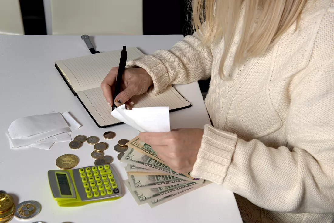 closeup-woman-hands-who-calculates-money-with-calculator-writes-notebook