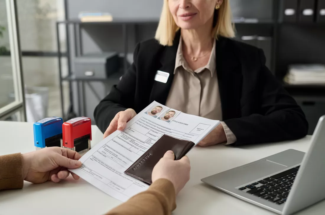 close-up-man-applying-visa-immigration-office-handing-documents-female-worker